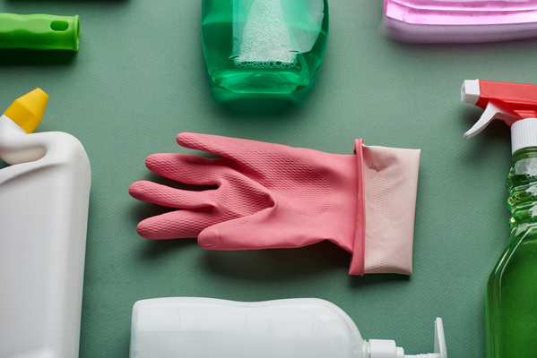 A pink rubber glove is among a set of household chemicals for total cleaning